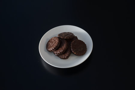 Biscuits covered with chocolate on both sides on a white plateの写真素材