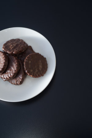 Biscuits covered with chocolate on both sides on a white plateの写真素材