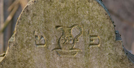 Old ancient abandoned jewish cemetery in the forest in the winter. Aged tombstones or gravestones in the graveyard.の写真素材