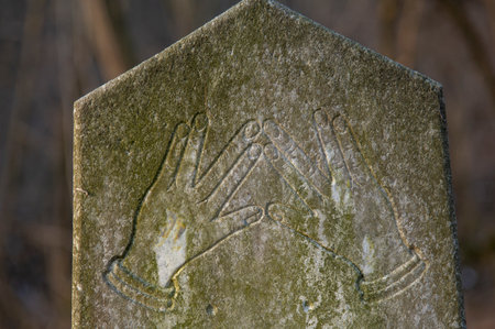 Old ancient abandoned jewish cemetery in the forest in the winter. Aged tombstones or gravestones in the graveyard.のeditorial素材