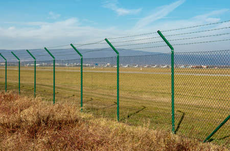 Green steel wire mesh fence around the airport area. Restricted area protection.の写真素材
