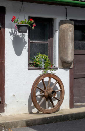 Antique vintage wooden carriage wheel hanging on the wall. Home rustic decorations.の写真素材