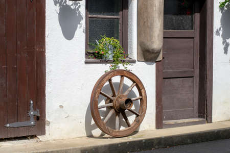 Antique vintage wooden carriage wheel hanging on the wall. Home rustic decorations.の写真素材