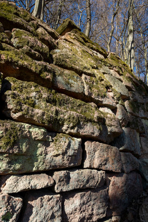 Ancient fragments of rock wall in the forest protecting road from landslide. Stone barrier.の写真素材