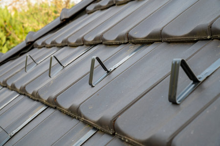 Snow guards, retainers  or snow hooks on the tile roof. Snow guards to keep snow from sliding off the roof too quickly.の写真素材