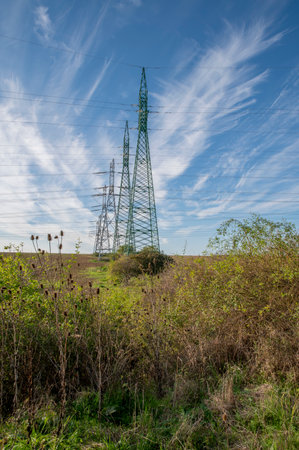 High voltage power lines and power pylons in the agricultural field. Electricity distribution.の写真素材