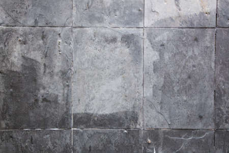 You can see a gray stone wall that is tiled and the structure of the wall looks irregularの写真素材