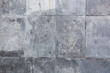 You can see a gray stone wall that is tiled and the structure of the wall looks irregularの写真素材