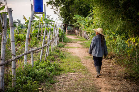 a woman walking down a path and looking to the side.の写真素材