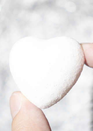 Creative Valentines Day love minimal composition made of man's fingers holding white heart on...