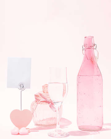 Valentine's Day
love creative concept of heart, decorative glass jar, bottle, champagne glass and paper card note on light pastel pink background. Aesthetic artistic.の写真素材