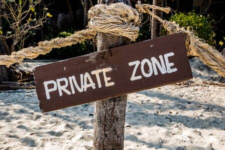 Wooden sign on sand beach saying private zonの写真素材