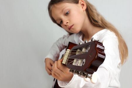 Girl with long hair is playing guitar