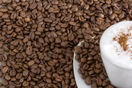 cup of cappuccino with many coffee beansの写真素材