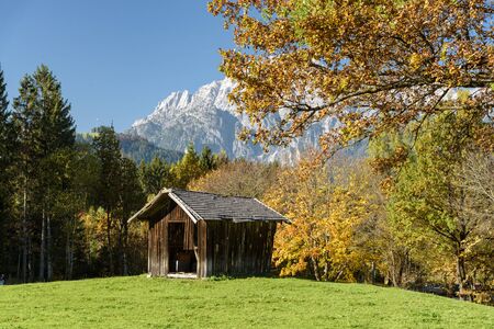 Small Hut at lake Ritzensee on a sunny autumn day in Saalfelden with the mountain Steinernes meer in the background in Saalfelden, Pinzgau, Salzburg Land, Austria.の写真素材