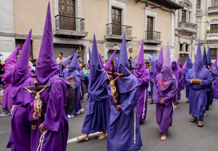 Quito, Pichincha, Ecuador - March 27, 2018: March of the Penitents at Good Friday procession at easter,  Semana Santa, in Quito. Cucuruchos wearing purple costumes of catholic practice.のeditorial素材