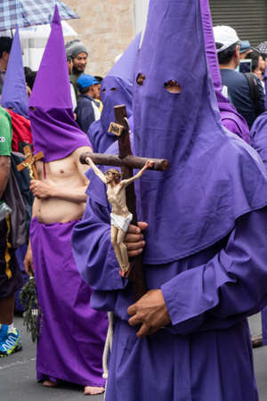 Quito, Pichincha, Ecuador - March 27, 2018: March of the Penitents at Good Friday procession at easter,  Semana Santa, in Quito. Cucuruchos wearing purple costumes of catholic practice.のeditorial素材