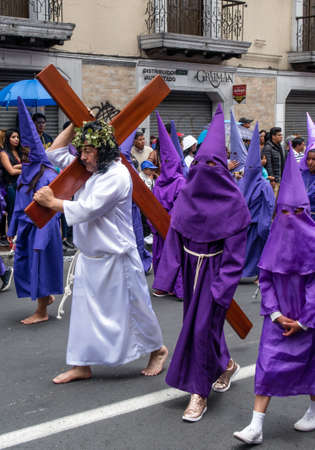 Quito, Pichincha, Ecuador - March 27, 2018: March of the Penitents at Good Friday procession at easter,  Semana Santa, in Quito. Cucuruchos wearing purple costumes of catholic practice.のeditorial素材