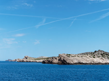 Rocky islands in blue water under partly cloudy skyの写真素材