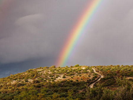 Scenic view of rainbow over mountain against skyの写真素材