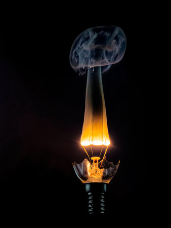 Close-up of illuminated light bulb against black background