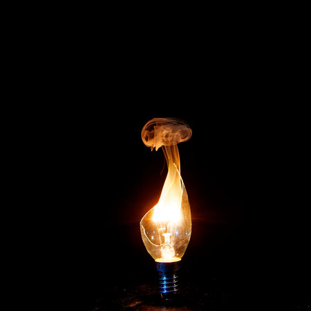 Burning incandescent lamp on a black background with copy spaceの写真素材
