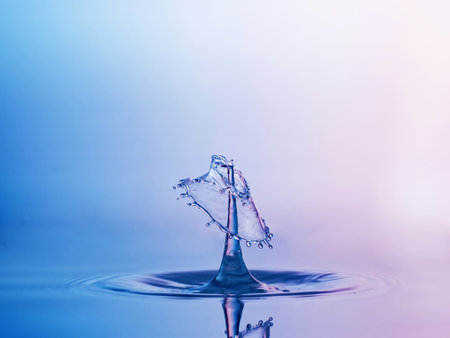 Falling drops of water. Splash effect after collision a falling drops with water surfaceの写真素材