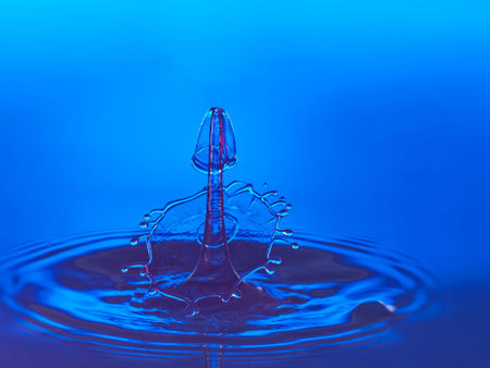 Falling drops of water. Splash effect after collision a falling drops with water surfaceの写真素材