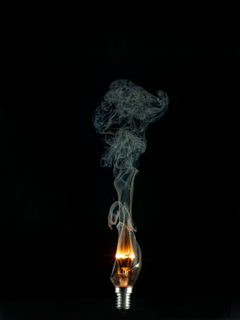 Incandescent lamp with smoke on a black background, close upの写真素材