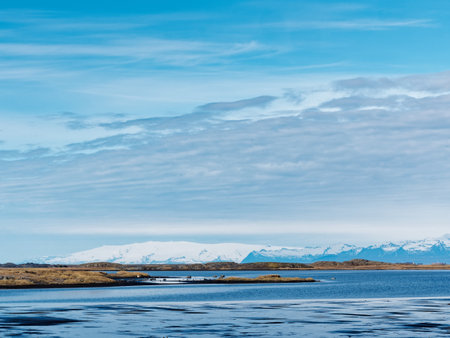 Icelandic landscape with snow-capped mountains in the backgroundの写真素材