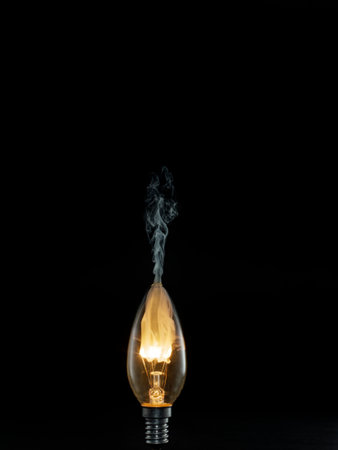Incandescent lamp with smoke on black background, low angle viewの写真素材