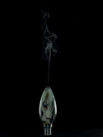 Incandescent light bulb with smoke on black background, incandescent lampの写真素材