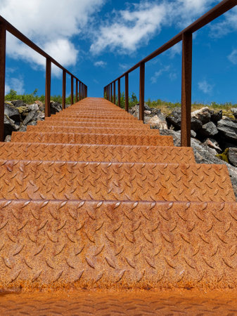 Staircase to the sea on a background of blue sky with cloudsの写真素材