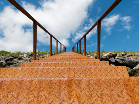Staircase leading up to a mountain with blue sky and cloudsの写真素材