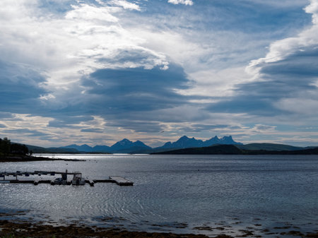 Beautiful landscape with mountains, lake and cloudy sky in Norway.