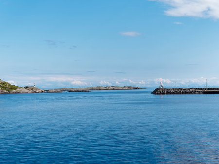 Lighthouse in the sea with blue sky and clouds