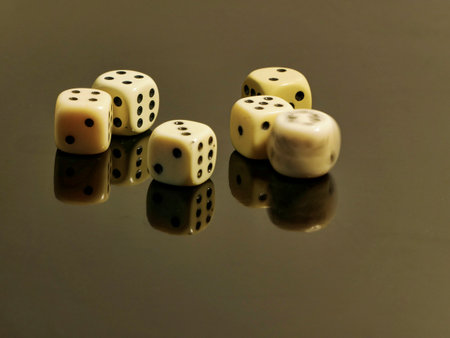 dice on a black background with reflection, closeup of photoの写真素材