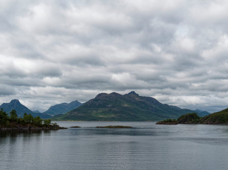 Norwegian landscape with mountains, fjord and cloudy sky.の写真素材