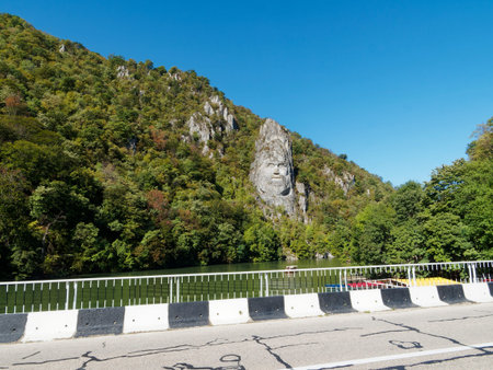 Sculpture of a man carved into the rock above the riverの写真素材