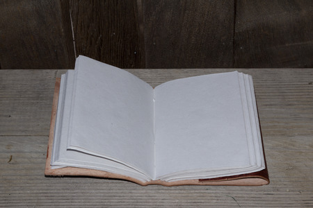 An open leather bound book with blank white pagesの写真素材