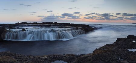 Panoramic of Victoria beach rocks with water flowing into the ocean at sunsetの写真素材