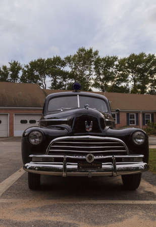 Orleans, Massachusetts, Cape Cod  - September 22, 2015: Black classic Chevrolet Special Deluxe police car parked in front of the Orleans police department. Editorial use only.のeditorial素材
