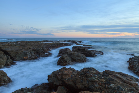 Sunset over the rocks at Shaws Cove in Laguna Beach as water flows over the stoneの写真素材