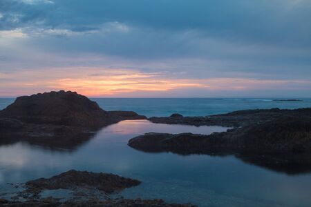 Long exposure of rocks in waves, giving a mist like effect over ocean in Laguna Beach, Californiaの写真素材