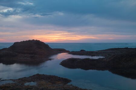 Long exposure of rocks in waves, giving a mist like effect over ocean in Laguna Beach, Californiaの写真素材