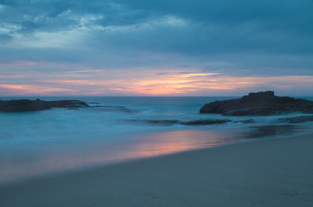 Long exposure of rocks in waves, giving a mist like effect over ocean in Laguna Beach, Californiaの写真素材
