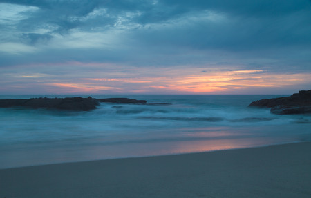 Long exposure of rocks in waves, giving a mist like effect over ocean in Laguna Beach, Californiaの写真素材