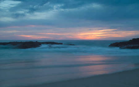 Long exposure of rocks in waves, giving a mist like effect over ocean in Laguna Beach, Californiaの写真素材