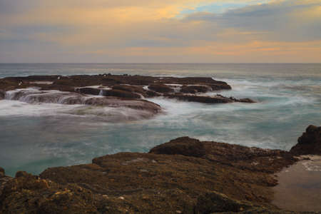 Long exposure of rocks in waves, giving a mist like effect over ocean in Laguna Beach, Californiaの写真素材