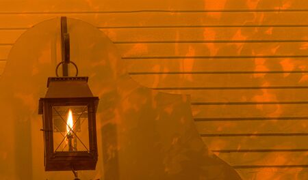 Lamp glows on the background of a house at nightの写真素材